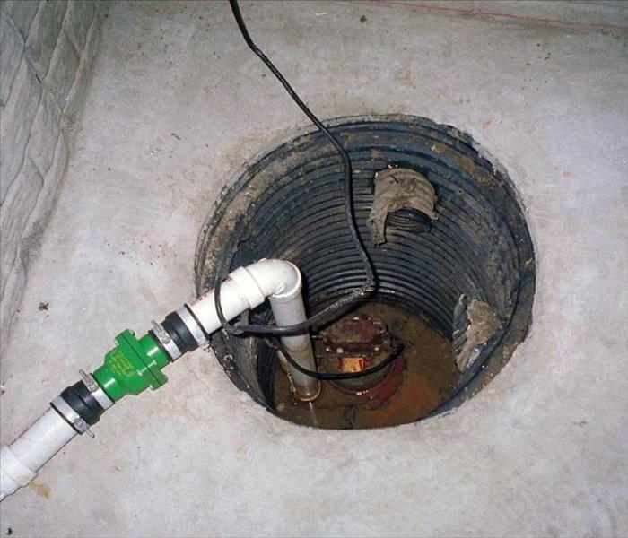 Sump pump hole in a basement.